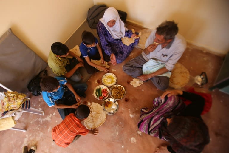 A Syrian family who has been evacuated from the town of Daraya share a breakfast upon their arrival at a government reception centre on August 27, 2016 in the government-held town of Hrajela in Western Ghouta, outside Damascus