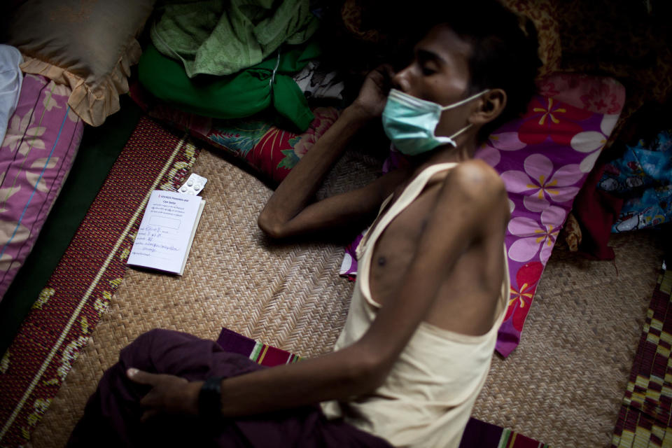 In this Sept. 1, 2012 photo, an HIV patient who is also infected with tuberculosis rests on a bed near his pills at an HIV/AIDS center on the outskirts of Yangon, Myanmar. Following a half century of military rule, care for HIV/AIDS patients in Myanmar lags behind other countries. Half of the estimated 240,000 people living with the disease are going without treatment and 18,000 are dying from it every year. (AP Photo/Alexander F. Yuan)