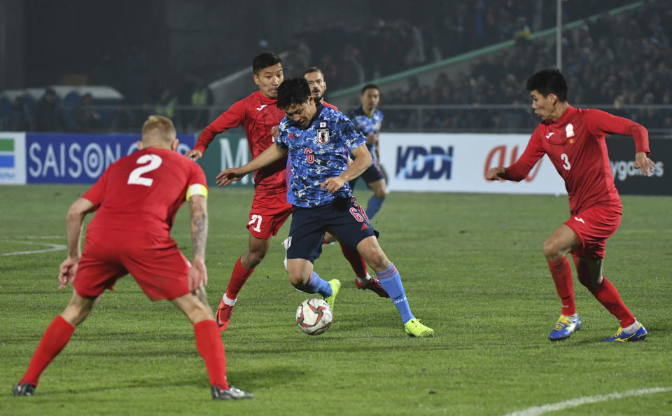 Japan's Water Endo, center, controls the ball during the World Cup 2022 Qualifying Asian zone Group F soccer match between Kyrgyzstan and Japan in Bishkek, Kyrgyzstan, Thursday, Nov. 14, 2019. (AP Photo/Vladimir Voronin)