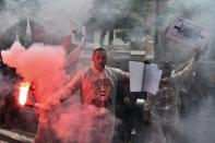 People hold smoke grenades during a protest against the labour market reforms in Paris, on May 26, 2016