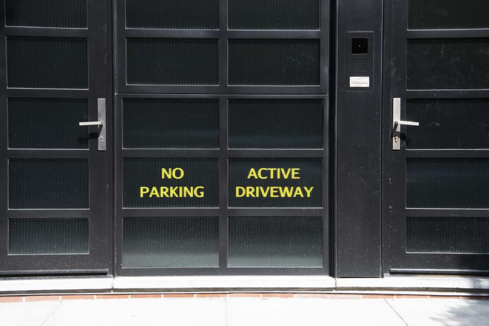 Signs on the back entrance to Noam Gottesman's complex read "No Parking" and "Active Driveway." (Photo: HuffPost / Damon Scheleur)