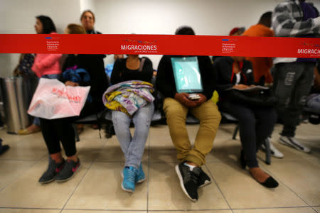 Immigrants wait at a state migration office at Santiago, Chile, December 22, 2016. Picture taken December 22, 2016. REUTERS/Ivan Alvarado