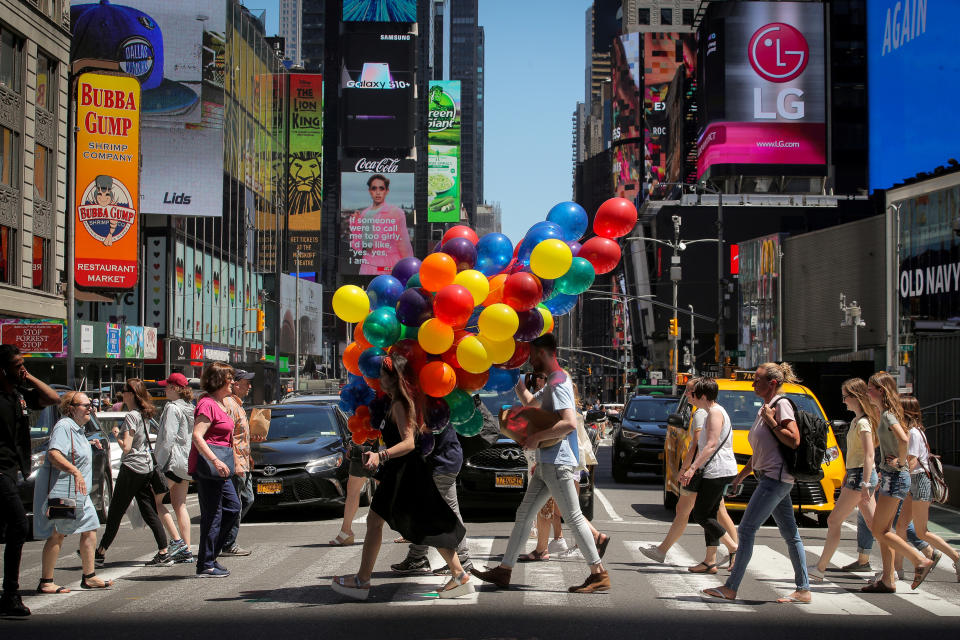 Una mujer camina por Times Square, en Nueva York (Estados Unidos), con un montón de globos el 26 de junio. (Foto: Brendan McDermid / Reuters).