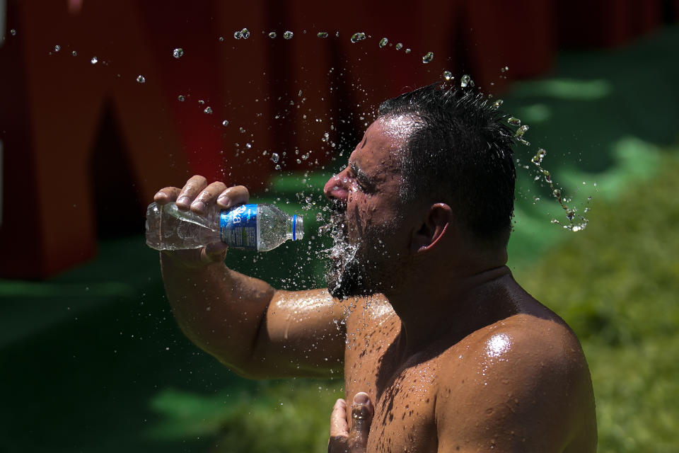 A wrestler cools off as he competes during the 663rd annual Historic Kirkpinar Oil Wrestling championship, in Edirne, northwestern Turkey, Saturday, July 6, 2024. Wrestlers take part in this "sudden death"-style traditional competition wearing only a pair of leather trousers and a good slick of olive oil. The festival is part of UNESCO's List of Intangible Cultural Heritages. (AP Photo/Khalil Hamra)