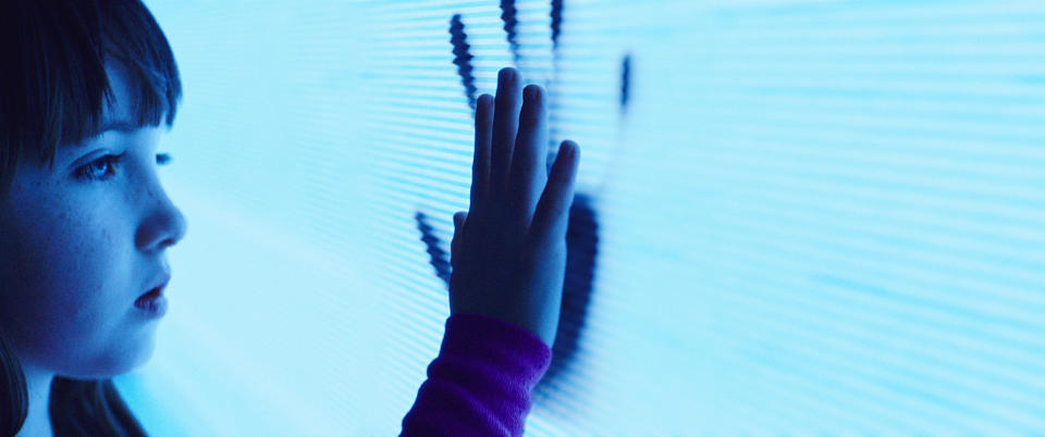 girl putting her hand up to a hand print