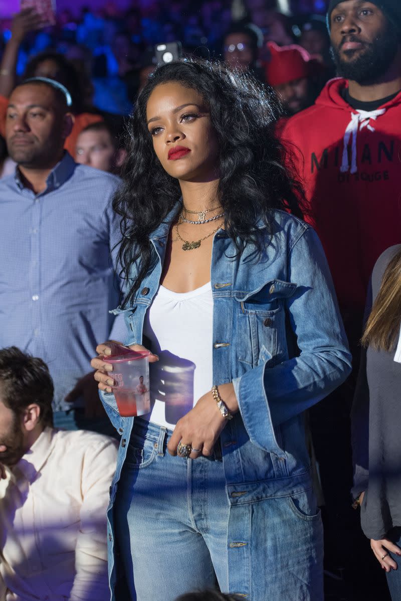 <p> Rihanna watches a boxing match in double denim and layered jewels. </p>