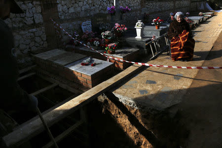 Ascension Mendieta, daughter of Timoteo Mendieta, who was shot in 1939, sits next a grave during the exhumation of her father's remains at Guadalajara's cemetery, Spain, January 31, 2016. REUTERS/Juan Medina