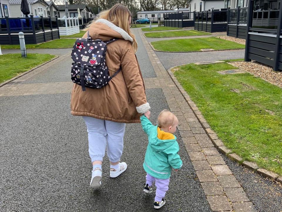 Katie Alexander and her daughter walking down the street with her holding hands.