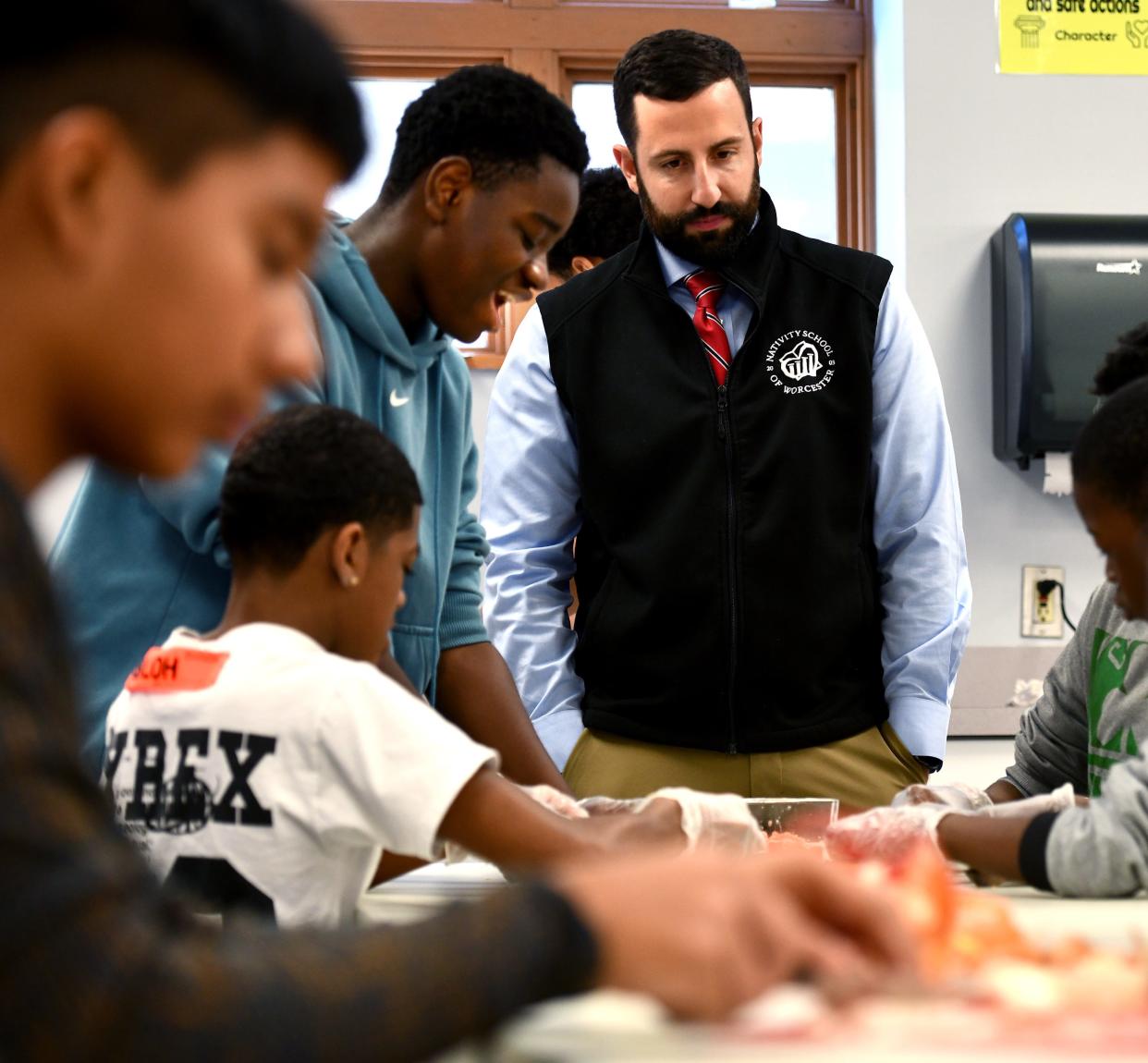 Nativity School of Worcester President Thomas McKenney, who announced the school is campaigning to open a girls' division, watches as eighth grade boys prepare salsa on Friday as part of the school's Hispanic Heritage Month celebration.