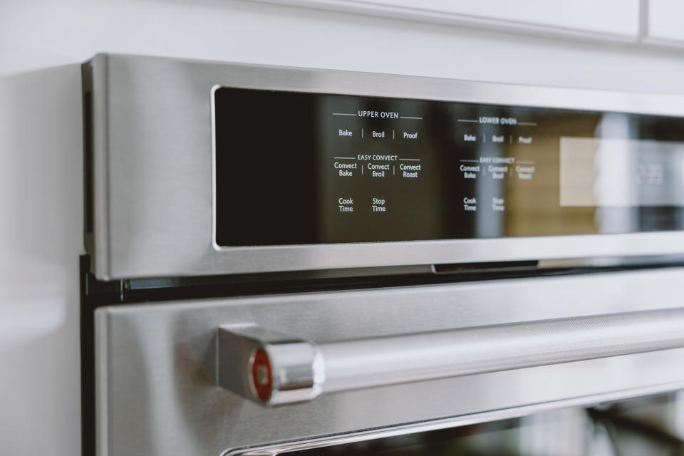 Close-up of a modern stainless steel oven with a digital control panel displaying options like Bake, Broil, and Connect. 