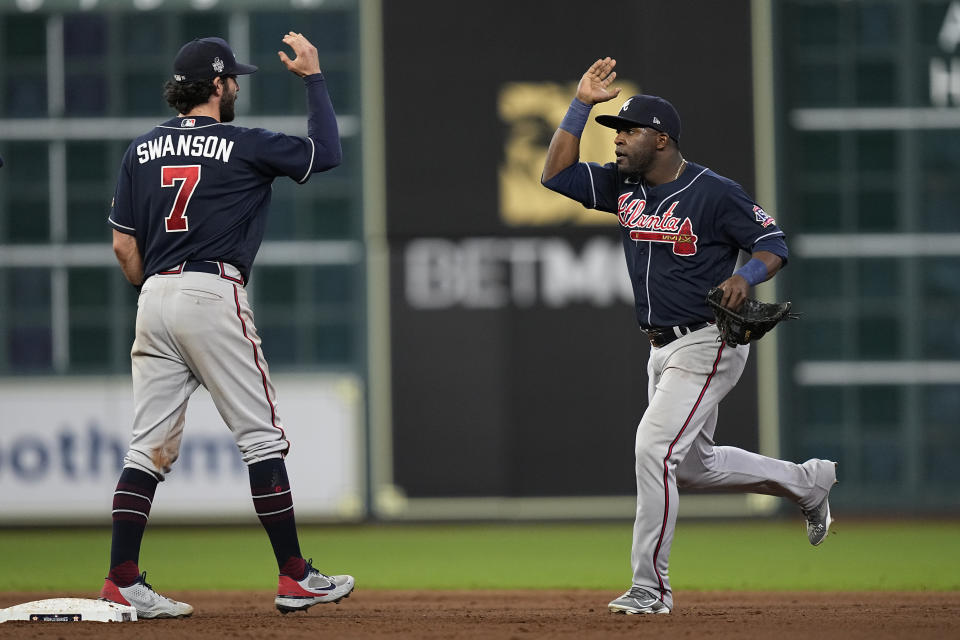 Atlanta Braves center fielder Guillermo Heredia and shortstop Dansby Swanson celebrates their win against the Houston Astros in Game 1 of baseball's World Series between the Houston Astros and the Atlanta Braves Tuesday, Oct. 26, 2021, in Houston. The Braves won 6-2. (AP Photo/David J. Phillip)