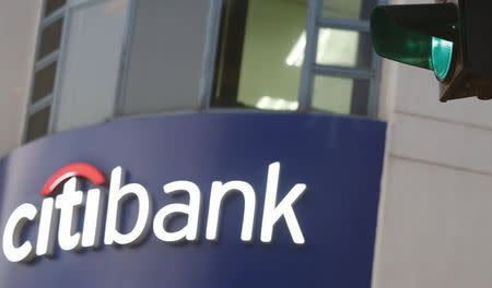 A green traffic light is pictured in front of a sign board of a Citibank branch in Hanoi, Vietnam July 8, 2015. REUTERS/Kham