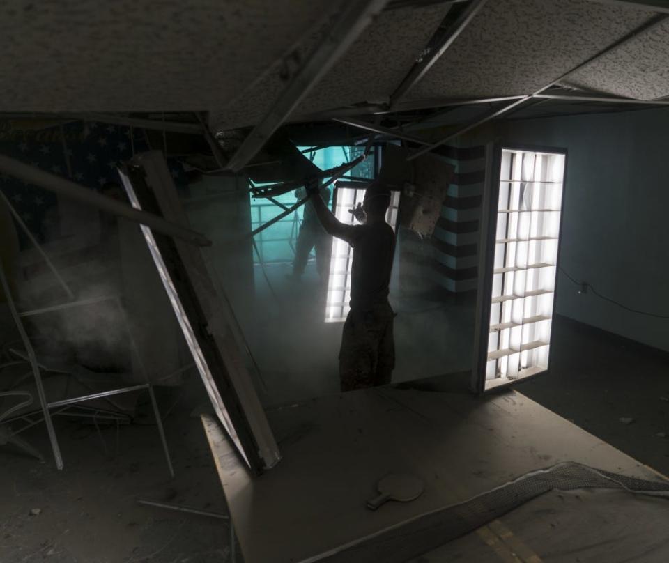 U.S. Air Force Staff Sgt. Matthew Parker, a U.S. Central Command Material Recovery Element technician, tears down broken metal and ceiling tiles the day after a Taliban-led attack on Bagram Airfield, Afghanistan, Dec. 12, 2019.