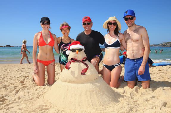 The McCormack family from Portland, Oregon pose alongside the sandcastle Christmas tree they made on Bondi Beach.