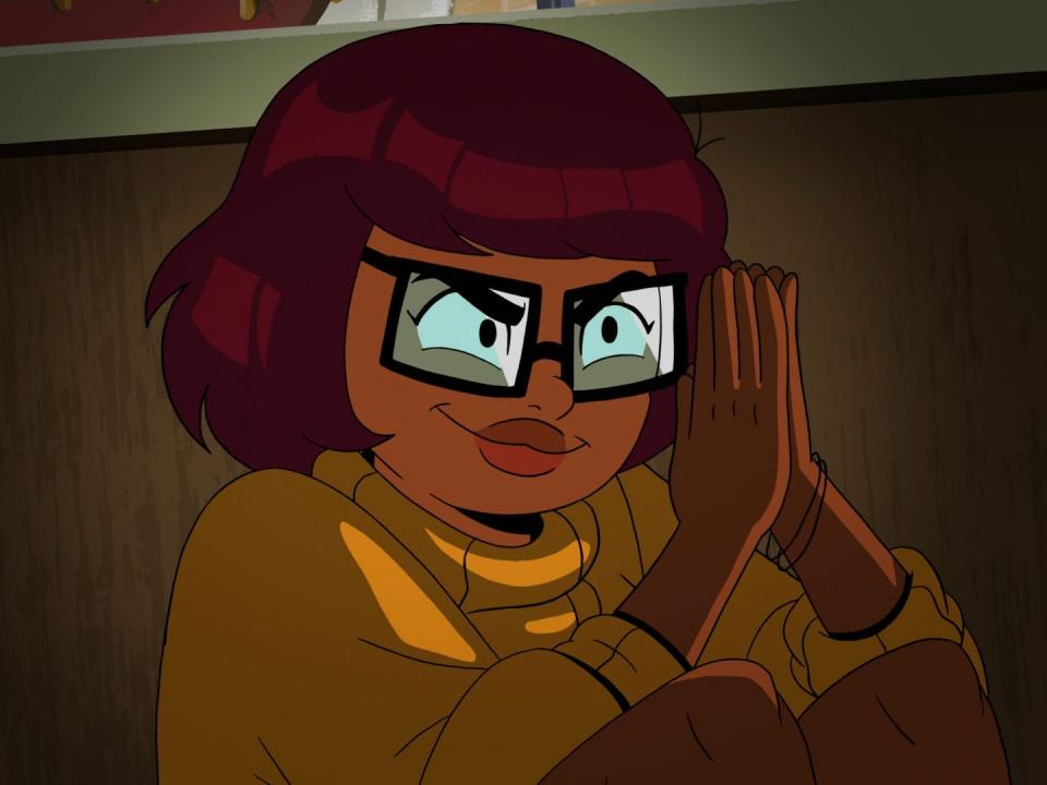 Velma holding her hands together and looking mischevious on HBO Max's animated series "Velma."