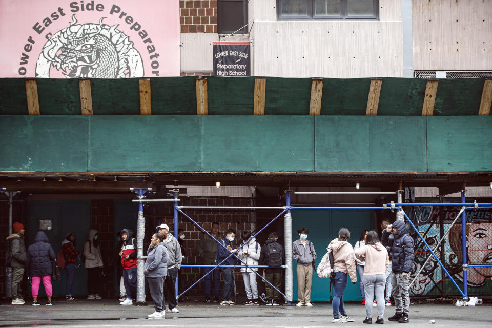 Students wait on premises to receive school laptops for home study at the Lower East Side Preparatory School, Thursday, March 19, 2020, in New York, as coronavirus restrictions shuttered classrooms throughout the city. New York Gov. Andrew Cuomo tightened work-from-home rules as confirmed cases continued to climb in New York, an expected jump as testing becomes more widespread. (AP Photo/John Minchillo)