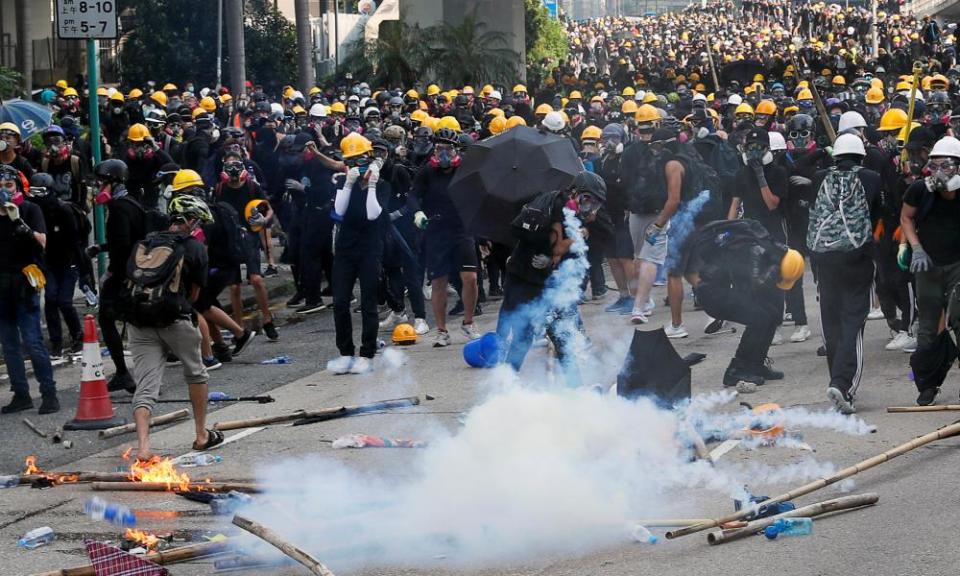 Protesters move away from teargas thrown by police.