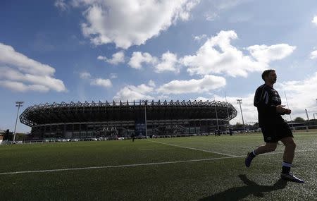 A member of the Edinburgh Rugby rugby team walks onto a pitch before practice outside Murrayfield Stadium in Edinburgh, Scotland April 29, 2014. REUTERS/Suzanne Plunkett