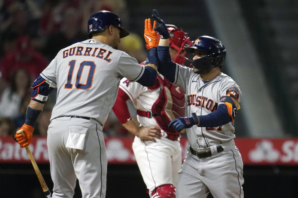 Houston Astros' Jose Altuve, right, celebrates his two-run home run with Yuli Gurriel (10) during the fifth inning of a baseball game against the Los Angeles Angels Tuesday, Sept. 21, 2021, in Anaheim, Calif. (AP Photo/Marcio Jose Sanchez)