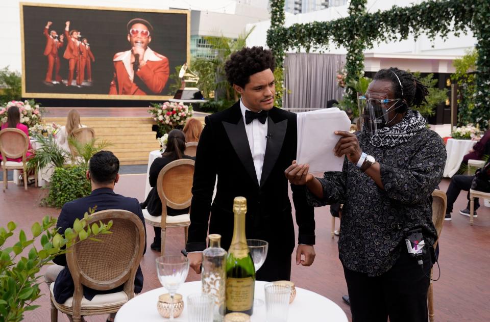 Grammys host Trevor Noah looks over details from the outdoor stage for in advance of Sunday's show as Anderson .Paak, right on screen, and Bruno Mars perform.