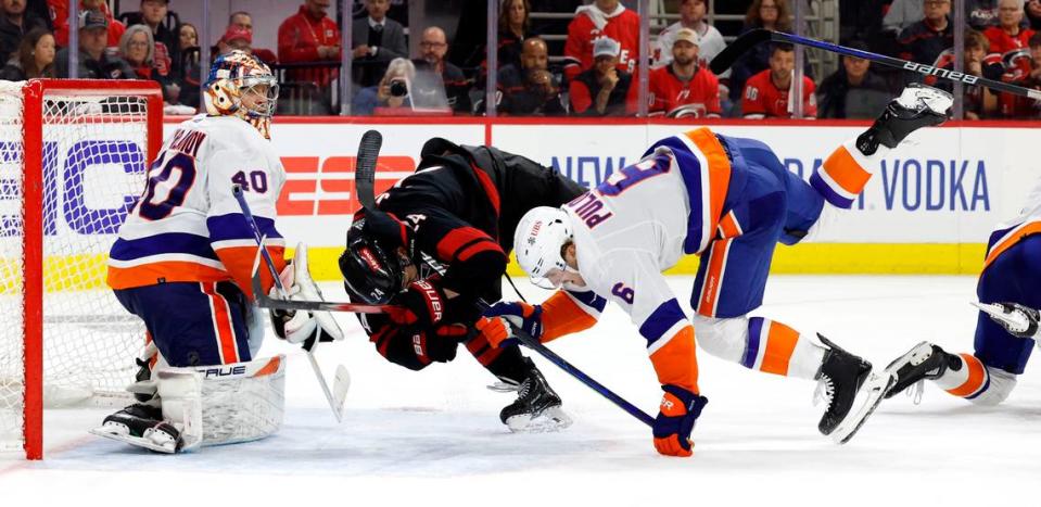 Carolina center Seth Jarvis (24) tangles with New York defenseman Ryan Pulock (6) in front of the goal during the third period of the Hurricanes’ 5-3 victory over the Islanders in the first round of the Stanley Cup playoffs at PNC Arena in Raleigh, N.C., Monday, April 22, 2024.