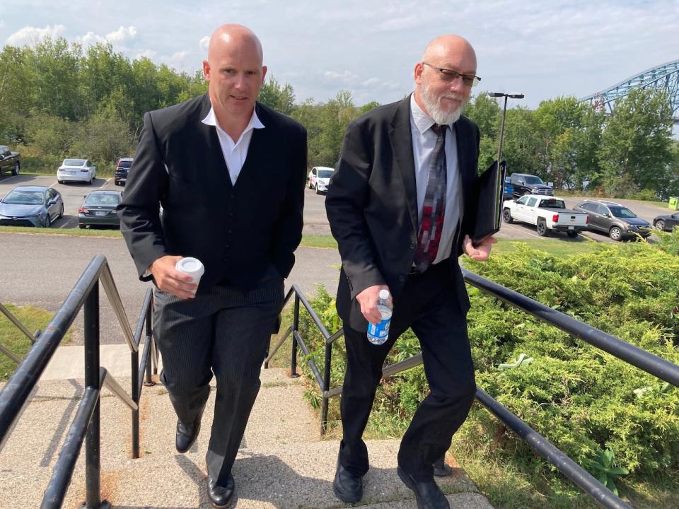 College lawyer Clarence Bennett (left) and executive director Tim Marshall arrive at court this morning. The college argues Cumberland's bullying of students and disruptive behaviour led to his firing.