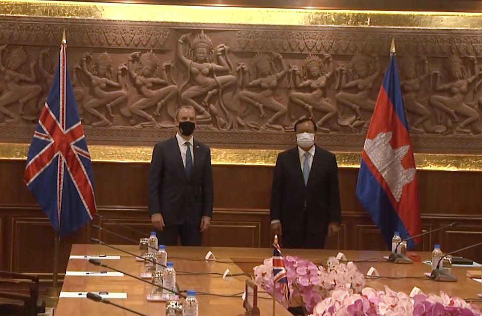 In this image made from video, Britain Foreign Secretary Dominic Raab, left, and Cambodia Foreign Minister Prak Sokhonn greet each other while social distancing to curb the spread of the coronavirus at the Foreign Ministry, Wednesday, June 23, 2021, in Phnom Penh, Cambodia. (AP Photo)