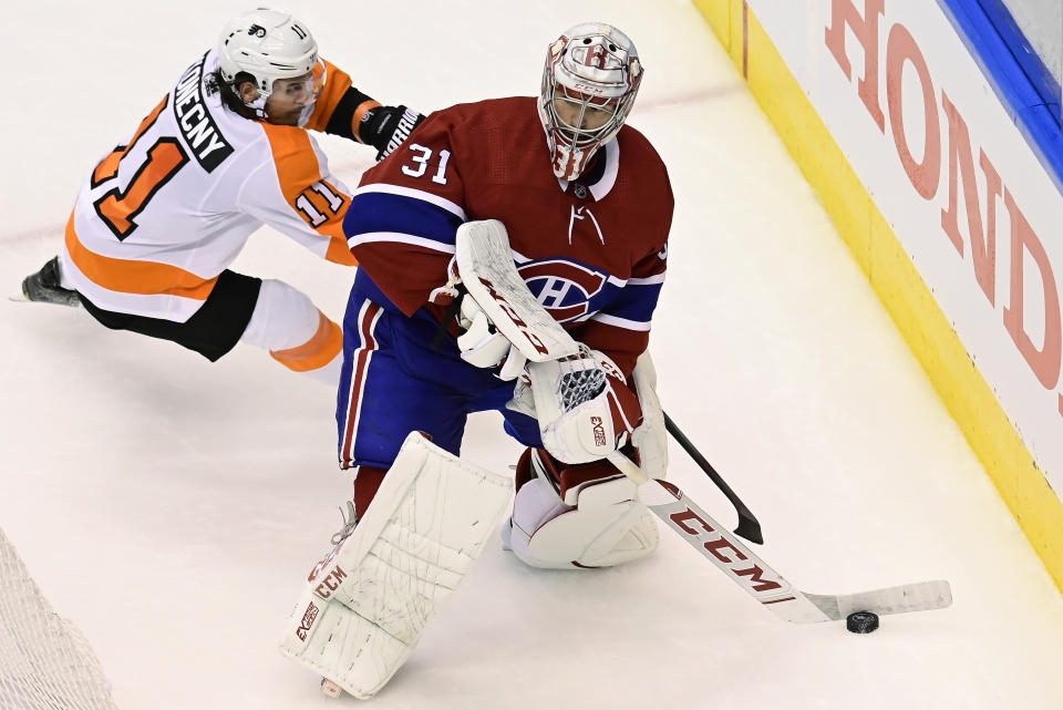 Philadelphia Flyers right wing Travis Konecny (11) looks for an opportunity as Montreal Canadiens goaltender Carey Price (31) clears the puck from behind the net during the second period of Game 3 of an NHL hockey playoff first-round series Sunday, Aug. 16, 2020, in Toronto. (Frank Gunn/The Canadian Press via AP)