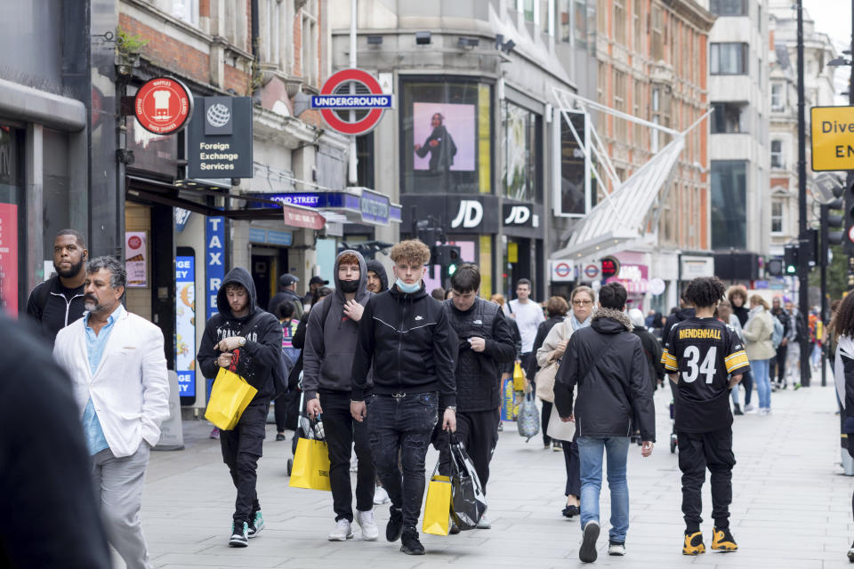 Shoppers seen walking with shopping bags along Bond Street in London. - Credit: Sipa USA via AP