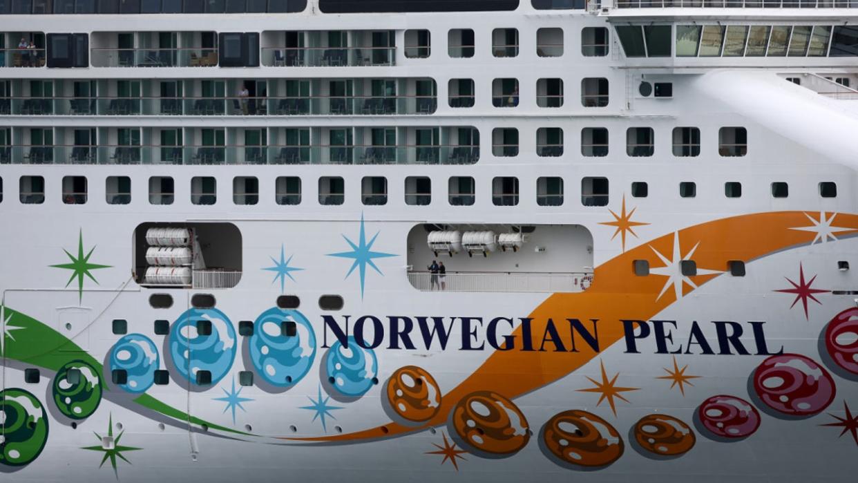 <div>MIAMI, FLORIDA - JANUARY 05: Passengers wait on the Norwegian Pearl as it docks at PortMiami on January 05, 2022 in Miami, Florida. (Photo by Joe Raedle/Getty Images)</div>