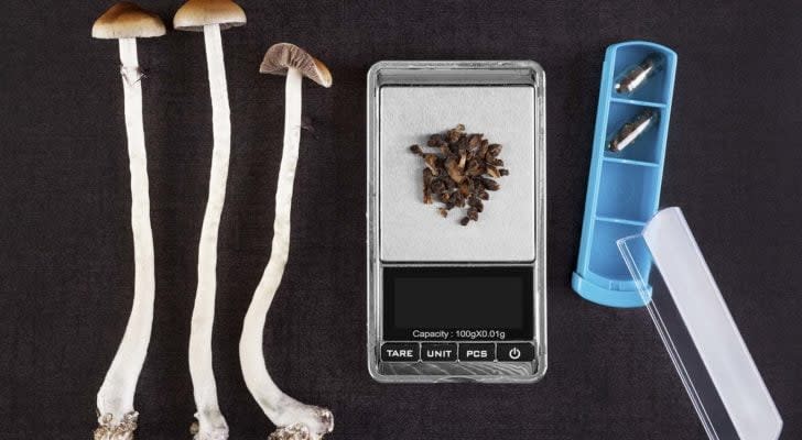 Mushrooms next to various medical tools; mushrooms in a pill container to represent psychedelic treatments