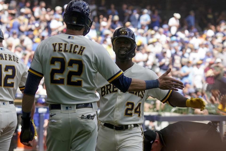 Milwaukee Brewers' Andrew McCutchen is congratulkated by Christian Yelich after hitting a two-run home run during the third inning of a baseball game against the Los Angeles Dodgers Thursday, Aug. 18, 2022, in Milwaukee. (AP Photo/Morry Gash)