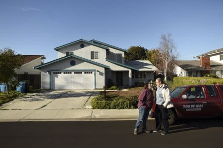 A Santa Clara resident, who asked to be identified as Qat Johnson, greets her husband Erik Johnson outside their home in Santa Clara, California January 27, 2016. REUTERS/Noah Berger