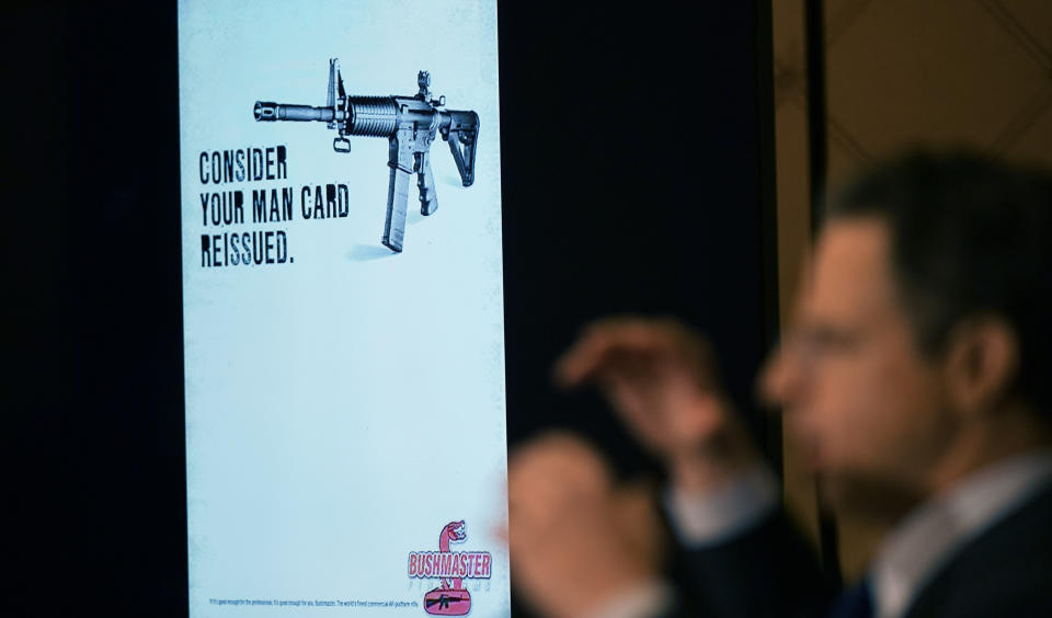 FILE - An advertising image for an AR-15-style rifle is displayed while attorney Josh Koskoff speaks during a news conference in Trumbull, Conn., Tuesday, Feb. 15, 2022. After agreeing to a $73 million lawsuit settlement with gun-maker Remington, the families of nine Sandy Hook Elementary School shooting victims say they are shifting their focus to ending firearms advertising. (AP Photo/Seth Wenig, File)