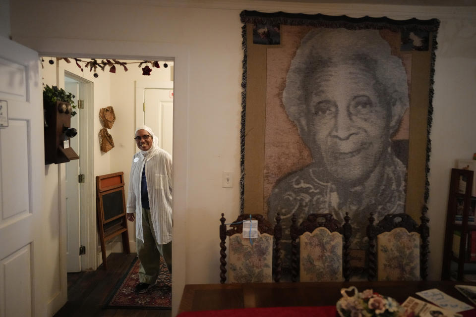 NY Nathiri, a third-generation town resident and founder of the Association to Preserve the Eatonville Community, walks through the Moseley House Museum, the restored home of Matilda Clark Moseley, niece of town founder Joe Clark and best friend of author Zora Neale Hurston, in Eatonville, Fla., Wednesday, Aug. 23, 2023. (AP Photo/Rebecca Blackwell)