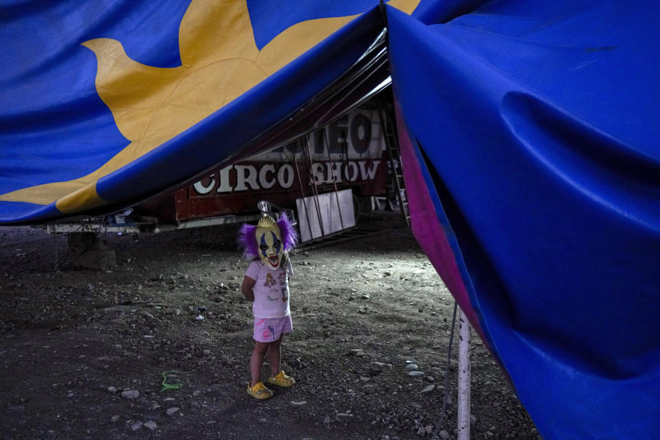 Mathilda Sanhueza, de 6 años, debajo de la carpa del Circo Timoteo, con una máscara de payaso, a las afueras de Santiago, Chile, el 20 de diciembre de 2022. El Circo Timoteo es un espectáculo que, durante más de medio siglo, ha combatidos los prejuicios y la discriminación contra comunidad LGBTQ de Chile. (AP Foto/Esteban Félix)