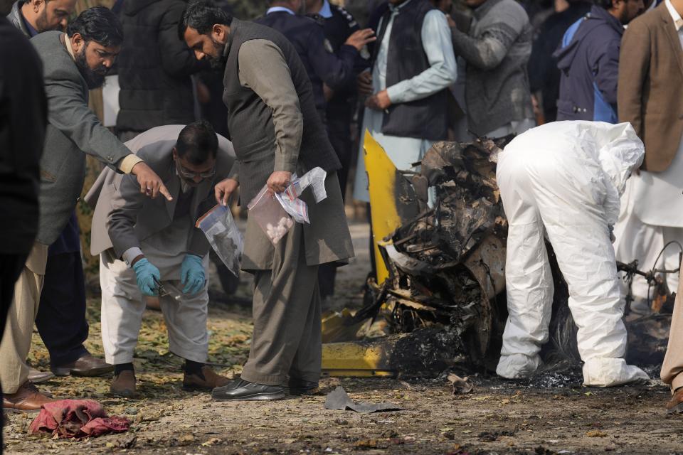 Investigators collect evidence at the site of bomb explosion, in Islamabad, Pakistan, Friday, Dec. 23, 2022. A powerful car bomb detonated near a residential area in the capital Islamabad on Friday, killing some people, police said, raising fears that militants have a presence in one of the country's safest cities. (AP Photo/Anjum Naveed)
