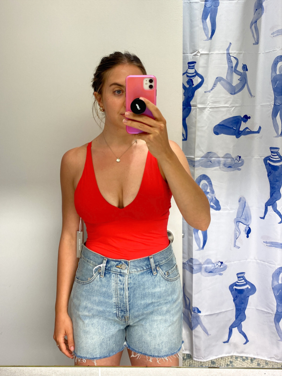 woman taking mirror selfie in bathroom wearing red bathing suit and blue denim shorts, everlane red swimsuit