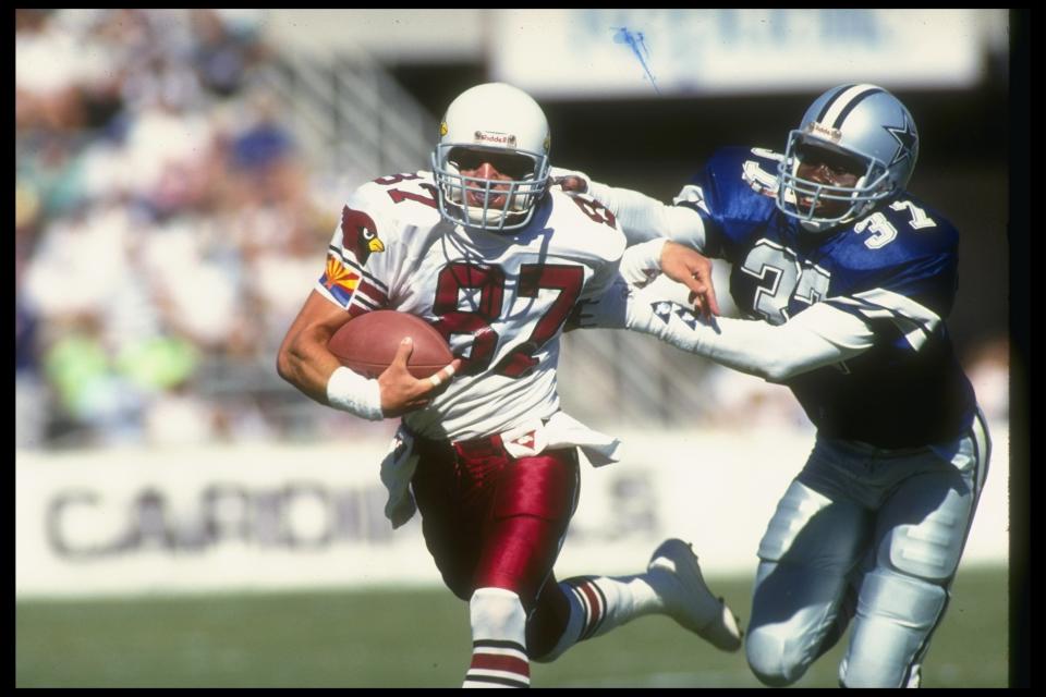 14 Oct 1990: Wide receiver Ricky Proehl of the Phoenix Cardinals attempts to break the tackle of Dallas Cowboys defensive back James Washington during a game at Sun Devil Stadium in Tempe, Arizona. The Cardinals won the game, 20-3.