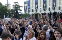 People react while listening to a speaker during a protest as opposition demonstrators gather in front of the Georgian Parliament building in Tbilisi, Georgia, Monday, June 24, 2019. Demonstrators have returned to parliament for daily rallies, demanding the release of detained protesters, the ouster of the nation's interior minister and changes in the electoral law to have legislators chosen fully proportionally rather than the current mix of party-list and single-mandate representatives. (AP Photo/Shakh Aivazov)