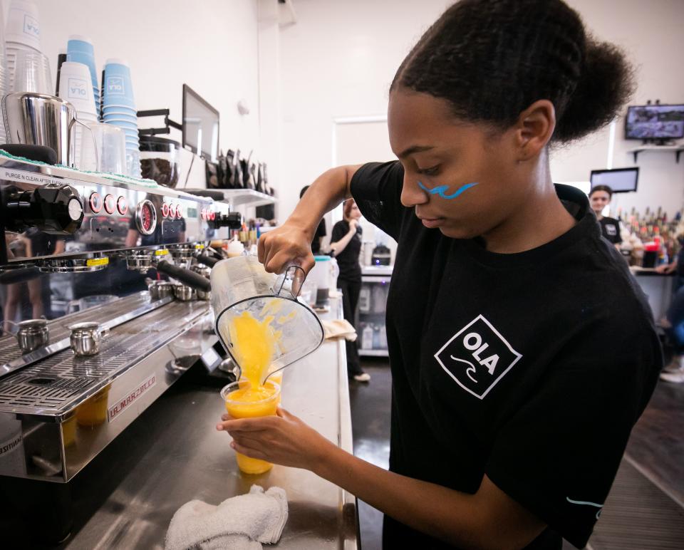 An OLA employee makes a smoothie for a customer on Friday.
