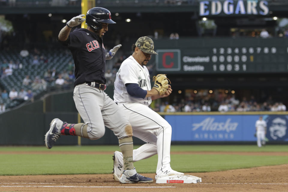 Seattle Mariners starting pitcher Justus Sheffield beats Cleveland Indians' Eddie Rosario to first base for an out during the sixth inning of a baseball game Saturday, May 15, 2021, in Seattle. (AP Photo/Jason Redmond)