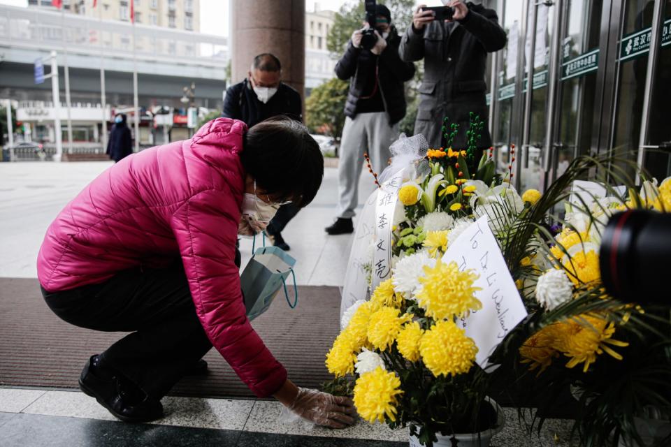 A mourner lays flowers in honor of Dr. Li Wenliang in Wuhan, China.