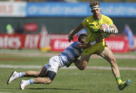 Australia's Ben O'Donnell, right, is tackled by Argentina's player in a quarterfinal match of the Emirates Airline Rugby Sevens in Dubai, the United Arab Emirates, Saturday, Dec. 1, 2018. (AP Photo/Kamran Jebreili)