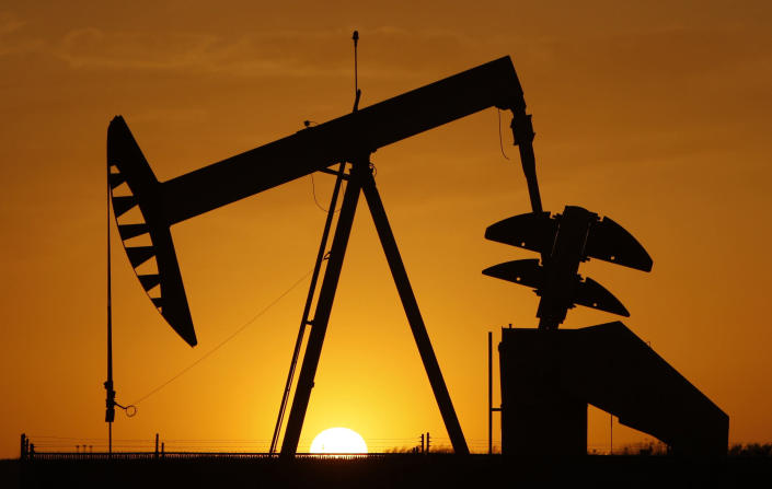 FILE- A pump jack is silhouetted against the setting sun in Oklahoma City on March 22, 2012. Minority neighborhoods where residents were long denied home loans have twice as many oil and gas wells as mostly white neighborhoods, according to a new study that suggests ongoing health risks in vulnerable communities are at least partly tied to historical structural racism. (AP Photo/Sue Ogrocki, File)