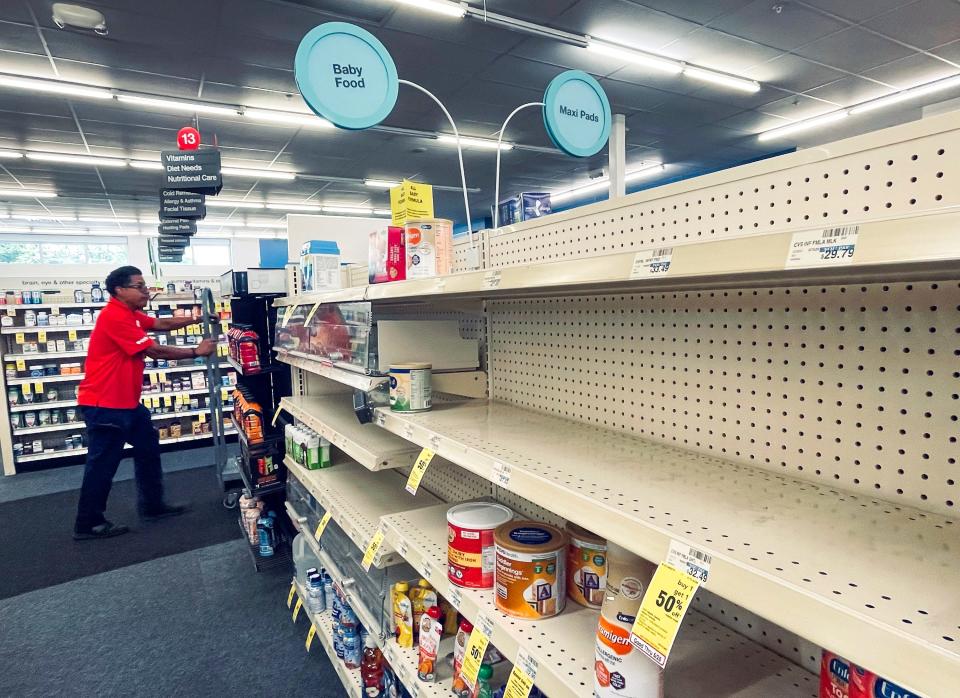 An employee walks past empty shelves where baby formula would normally be located at a CVS in New Orleans on Monday, May 16, 2022. President Joe Biden&#39;s administration has announced new steps to ease the national shortage of baby formula, including allowing more imports from overseas.