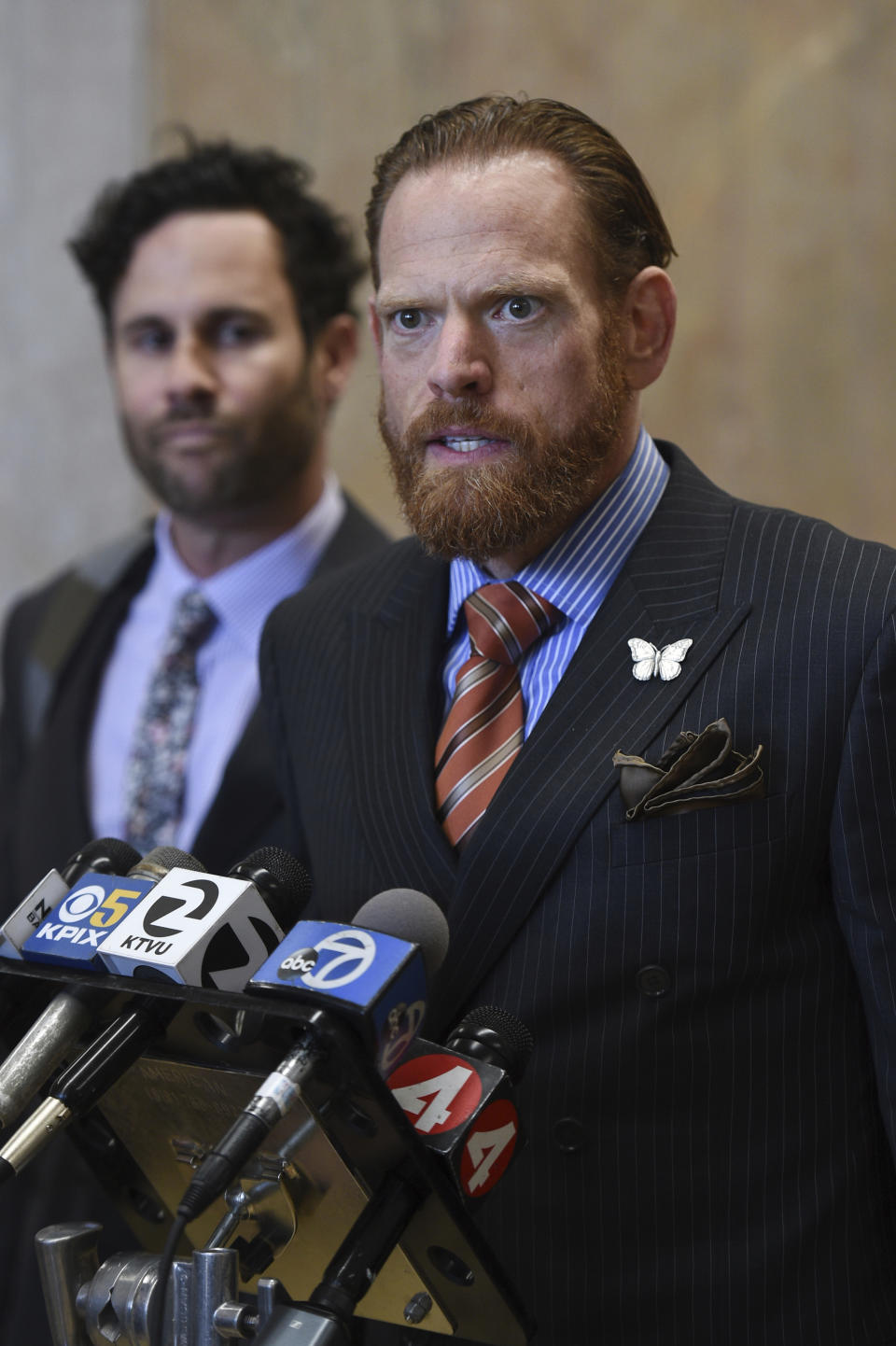 Attorneys Curtis Briggs, foreground, and Tyler Smith, who represent Max Harris, speak to the media at the Alameda County Courthouse in Oakland, Calif., Tuesday April, 30, 2019. Two defendants, Derick Almena and Harris are standing trial on charges of involuntary manslaughter after a 2016 fire killed 36 people at a warehouse party they hosted in Oakland. (AP Photo/Cody Glenn)