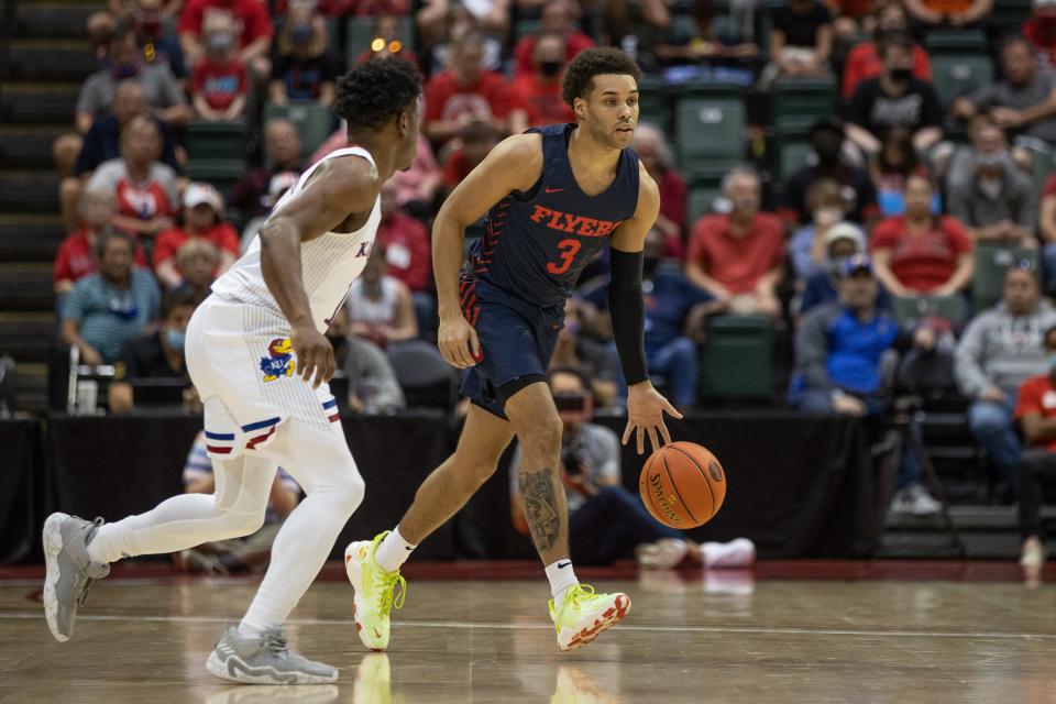 Flyers guard Lynn Greer III dribbles against the Jayhawks in the first half.