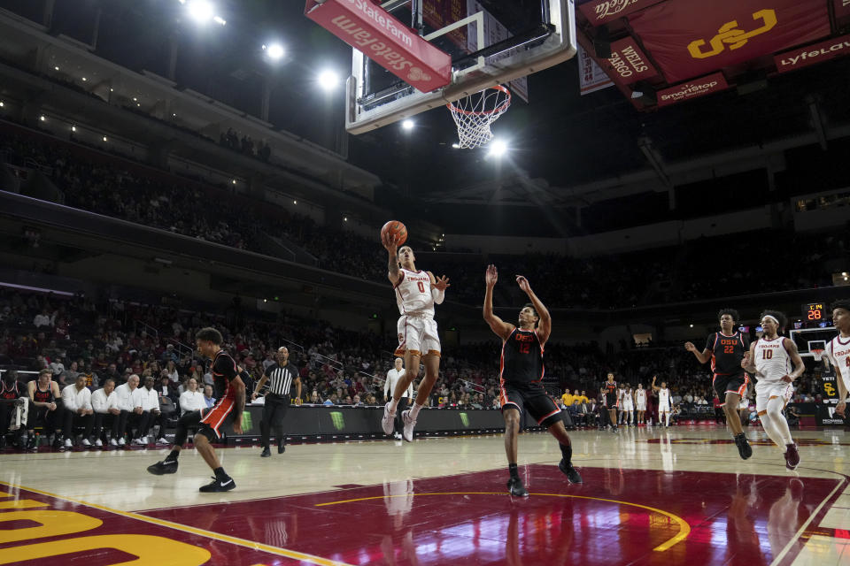 Southern California guard Kobe Johnson (0) goes to the basket against ,Oregon State forward Michael Rataj (12) during the first half of an NCAA college basketball game in Los Angeles, Saturday, Feb. 3, 2024. (AP Photo/Eric Thayer)