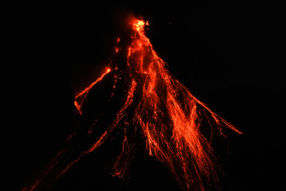 Lava flows down the slopes of Mayon volcano as seen from Legazpi, Albay province, northeastern Philippines, Thursday, June 15, 2023. Thousands of residents have left the mostly poor farming communities within a 6-kilometer (3.7-mile) radius of Mayon's crater in forced evacuations since volcanic activity spiked last week. (AP Photo/Aaron Favila)